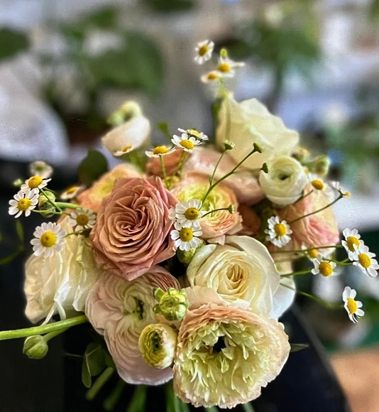 Composizione floreale bianca con gigli e rose in un vaso su un tavolo di legno in una chiesa