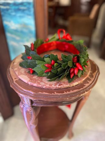 Mani che dispongono fiori bianchi e rosa in una ghirlanda su un tavolo