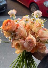 Vivace bouquet misto in un vaso su un tavolo di legno in una cucina illuminata dal sole
