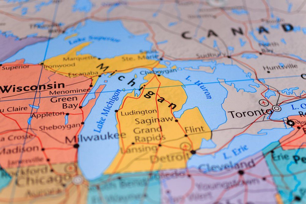 Map of the Midwest, highlighting Michigan and surrounding Great Lakes. Cities and states labeled in various colors.