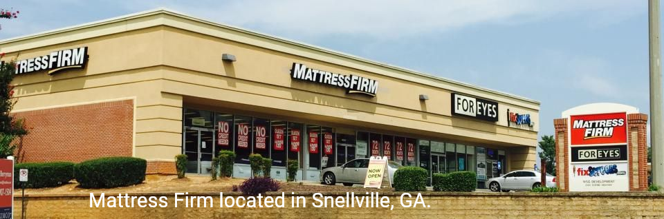 Morris Furniture store exterior in a tan strip mall with red and black signage and a roadside sign.