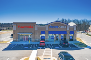 Vibroworks and Aspen Dental storefronts in a strip mall, with parked cars and snowy surroundings