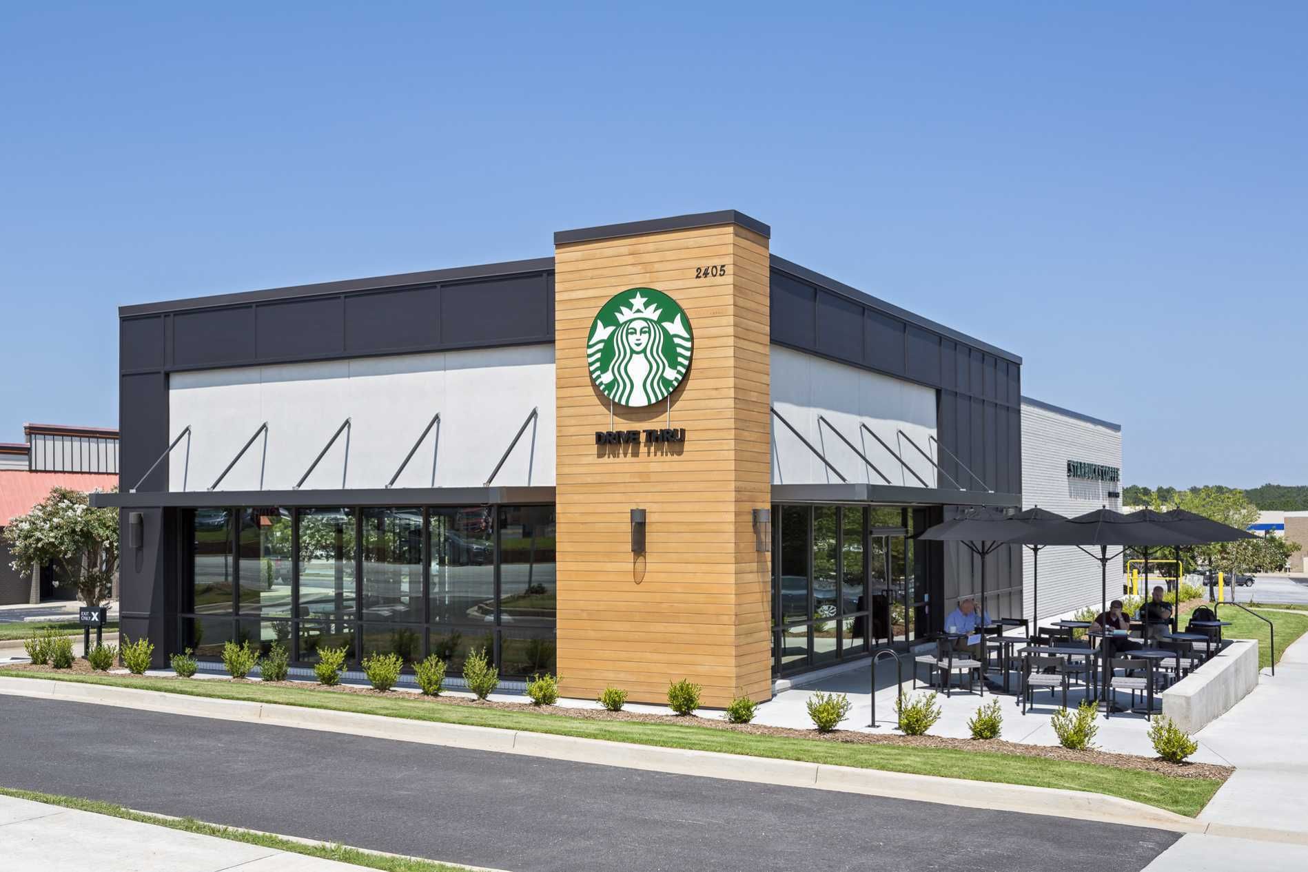 Starbucks coffee shop exterior with patio seating and green logo sign