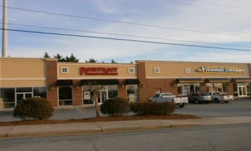 Strip mall storefronts with a Red Robin restaurant and adjacent shops on a cloudy day