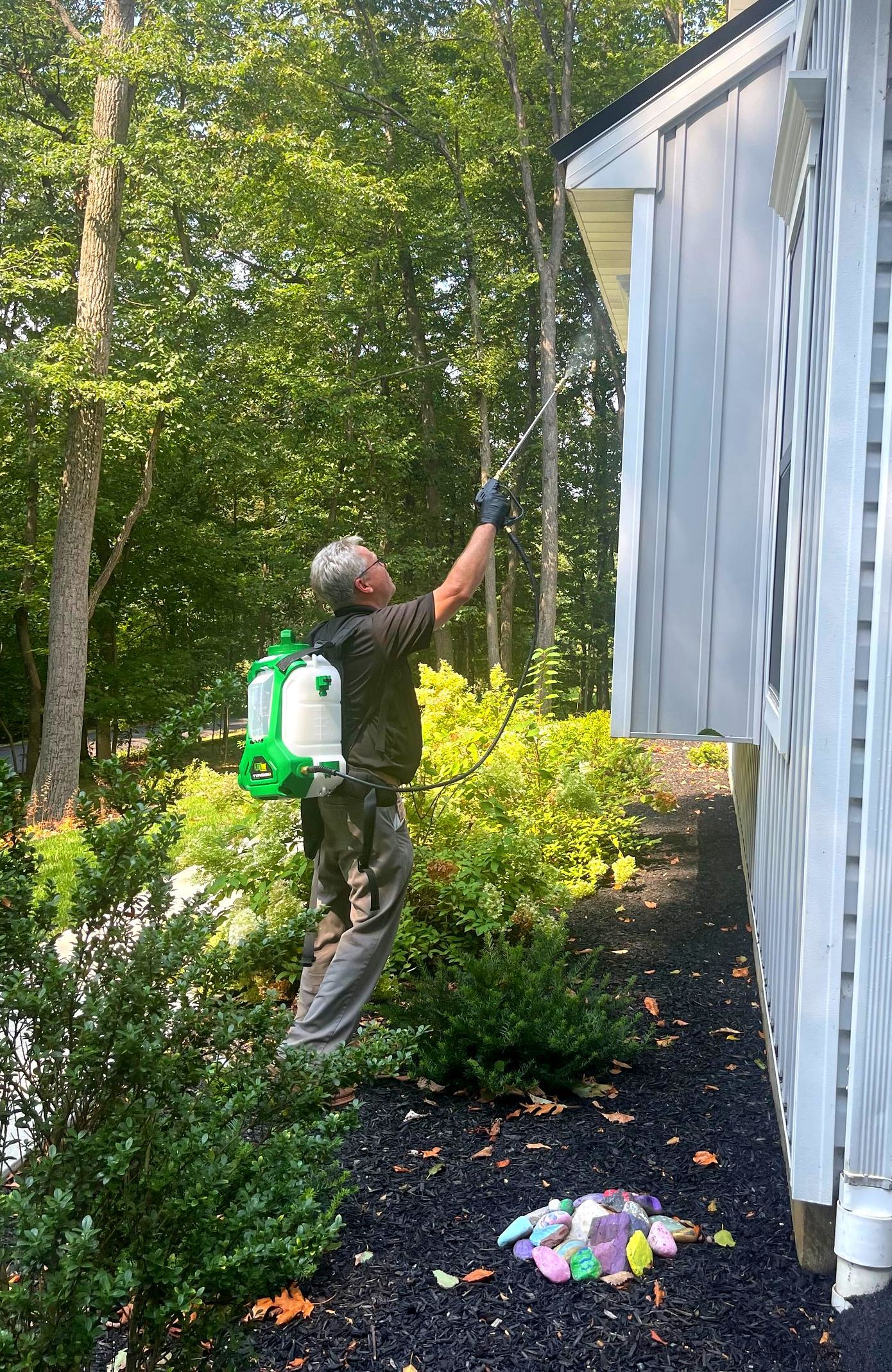 Rob of keystone pest solutions LLC is spraying house siding for pest control treatment in Columbia PA
