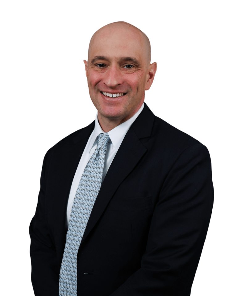 Keith Anthony in a dark suit and light blue tie against a white background