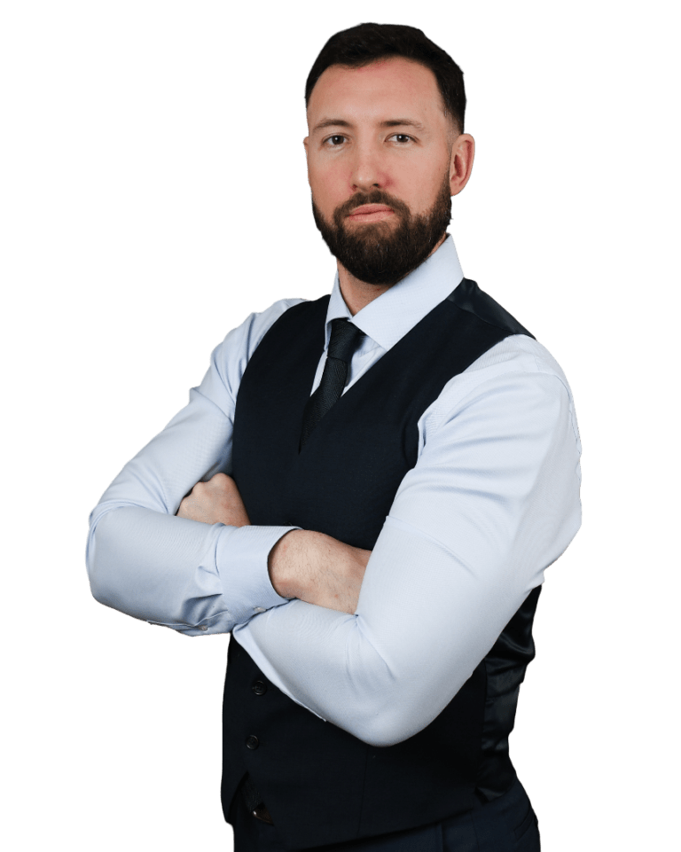 Portrait of a man in a white shirt, navy vest, and tie, standing with arms crossed on a white background