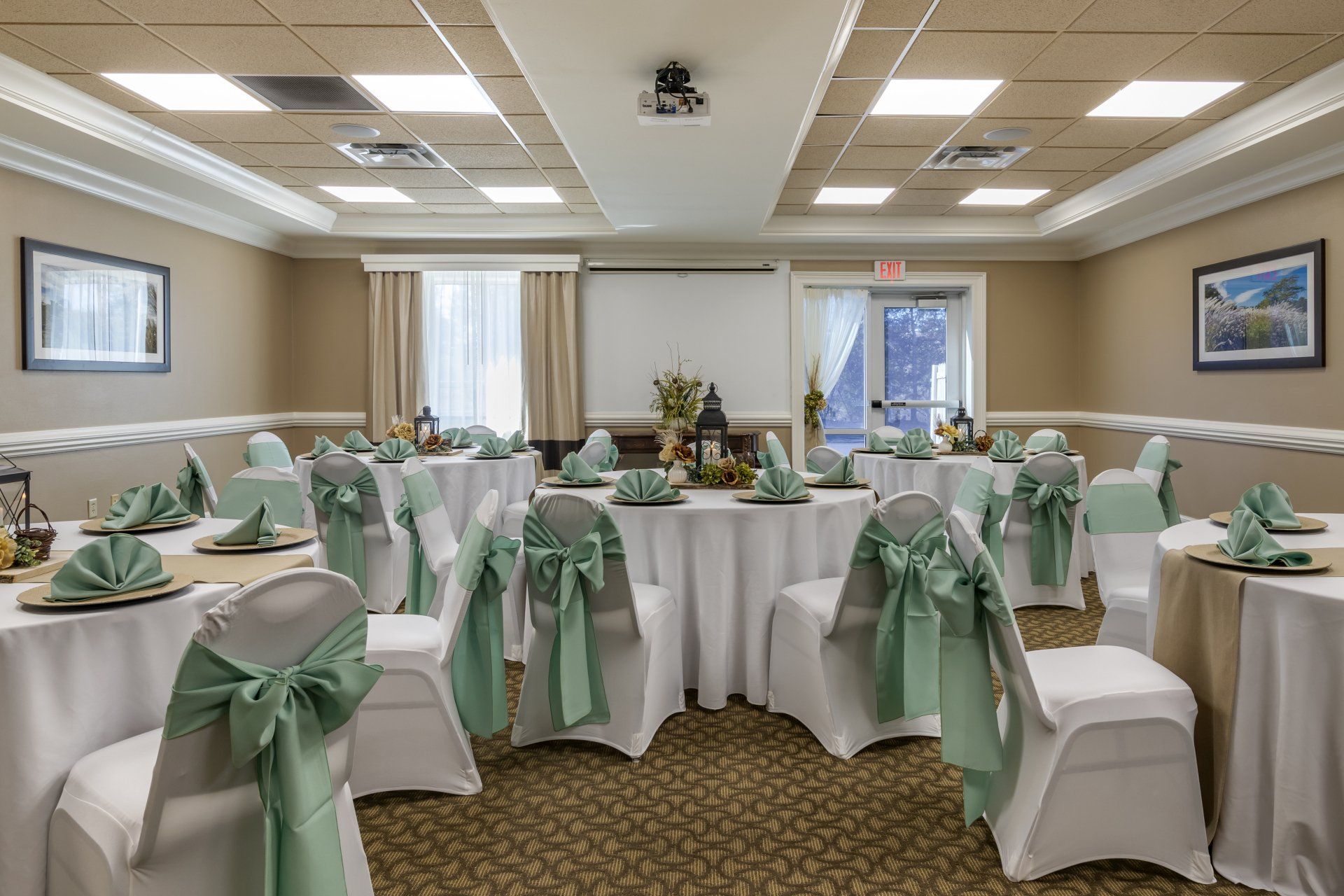 Conference room with red chairs and flowered tables at the Comfort Inn and Suites in Tifton, GA.