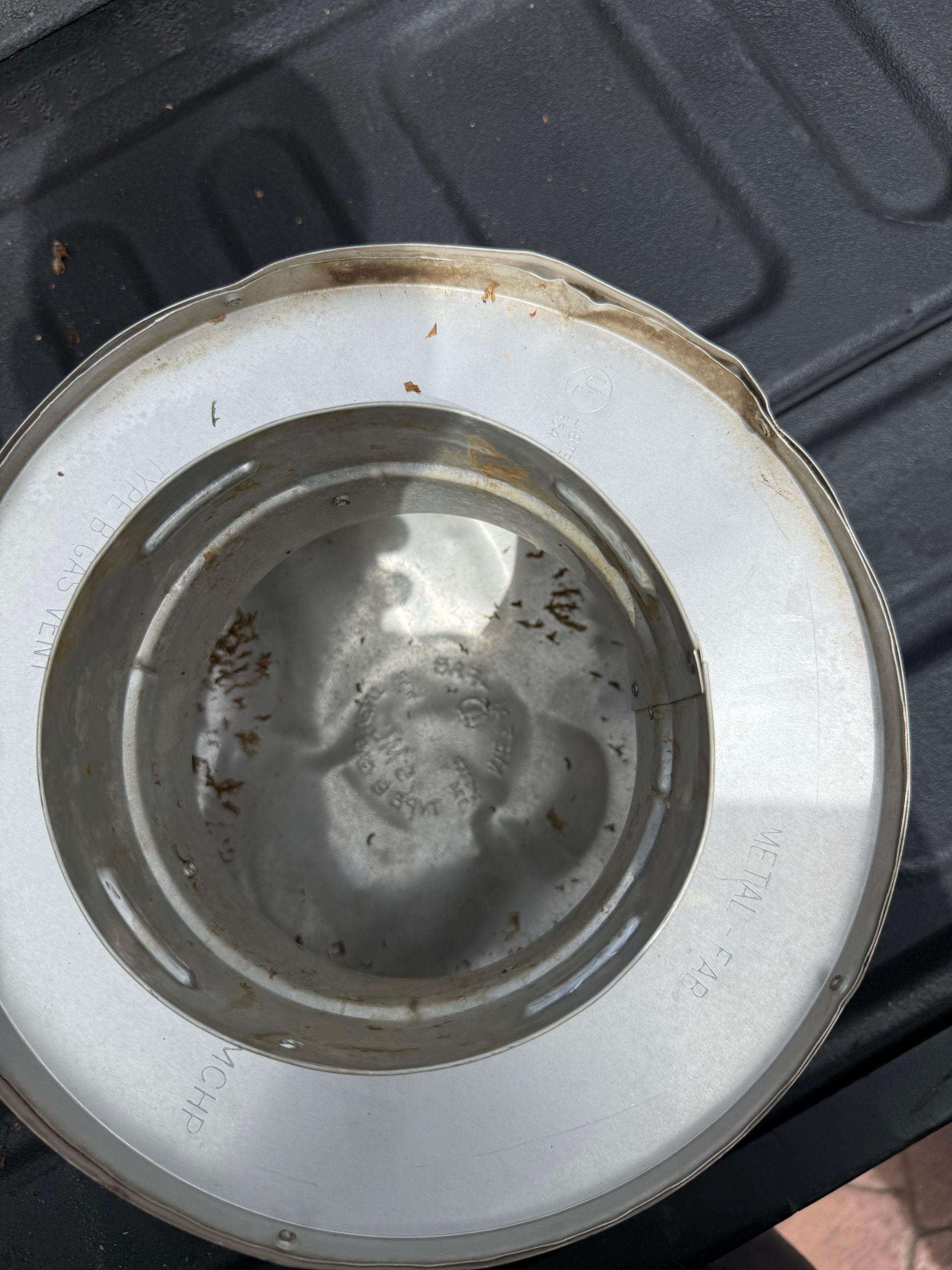 White ceramic bowl with water and residue, resting on a dark ridged surface.