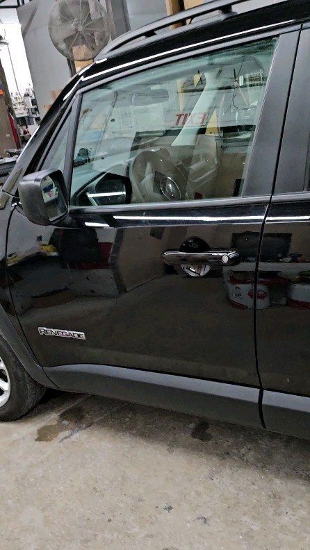 Black SUV parked on a street, showing the side door and window.