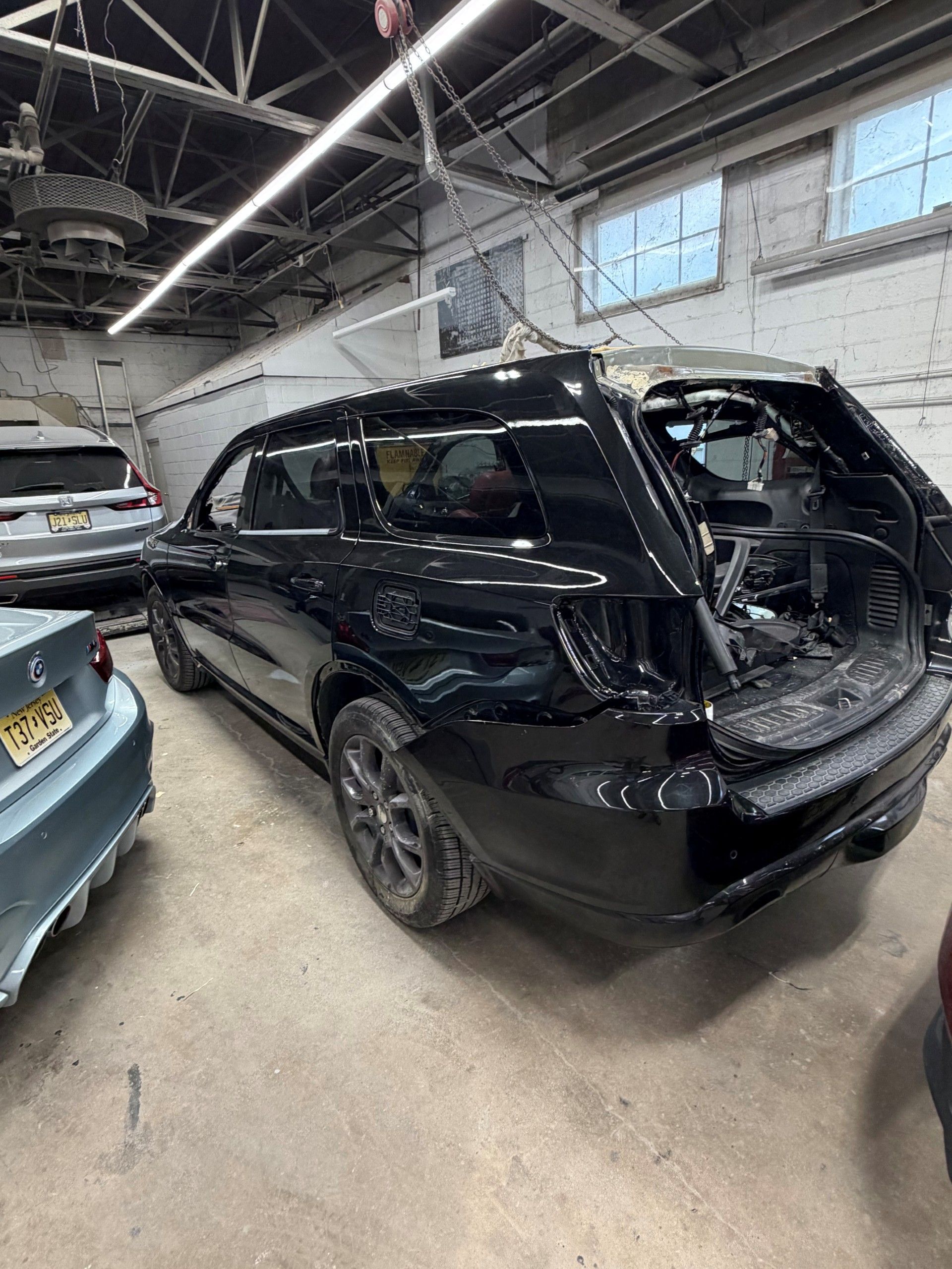Mechanic grinding a car fender, sending sparks in an auto repair shop
