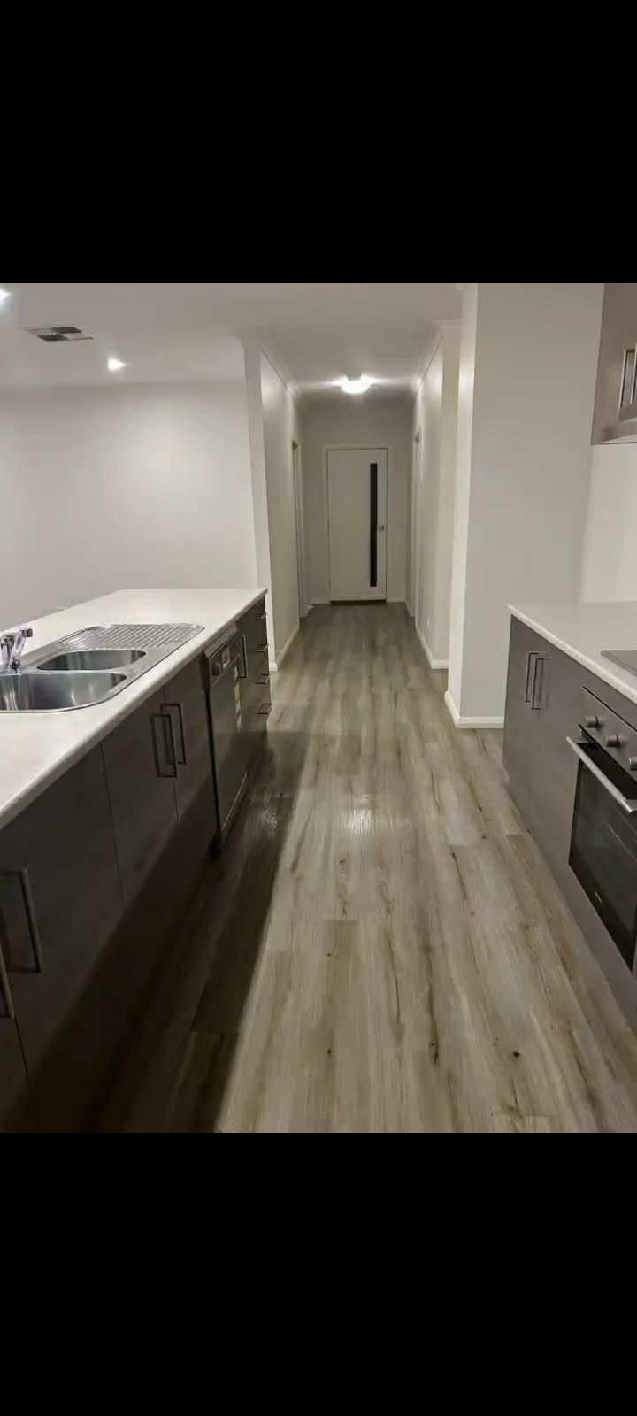 Modern Kitchen Hallway With White Walls, Gray Cabinets, Wood Flooring, and Recessed Ceiling Lights — A Plus Project Maintenance in Wodonga, VIC