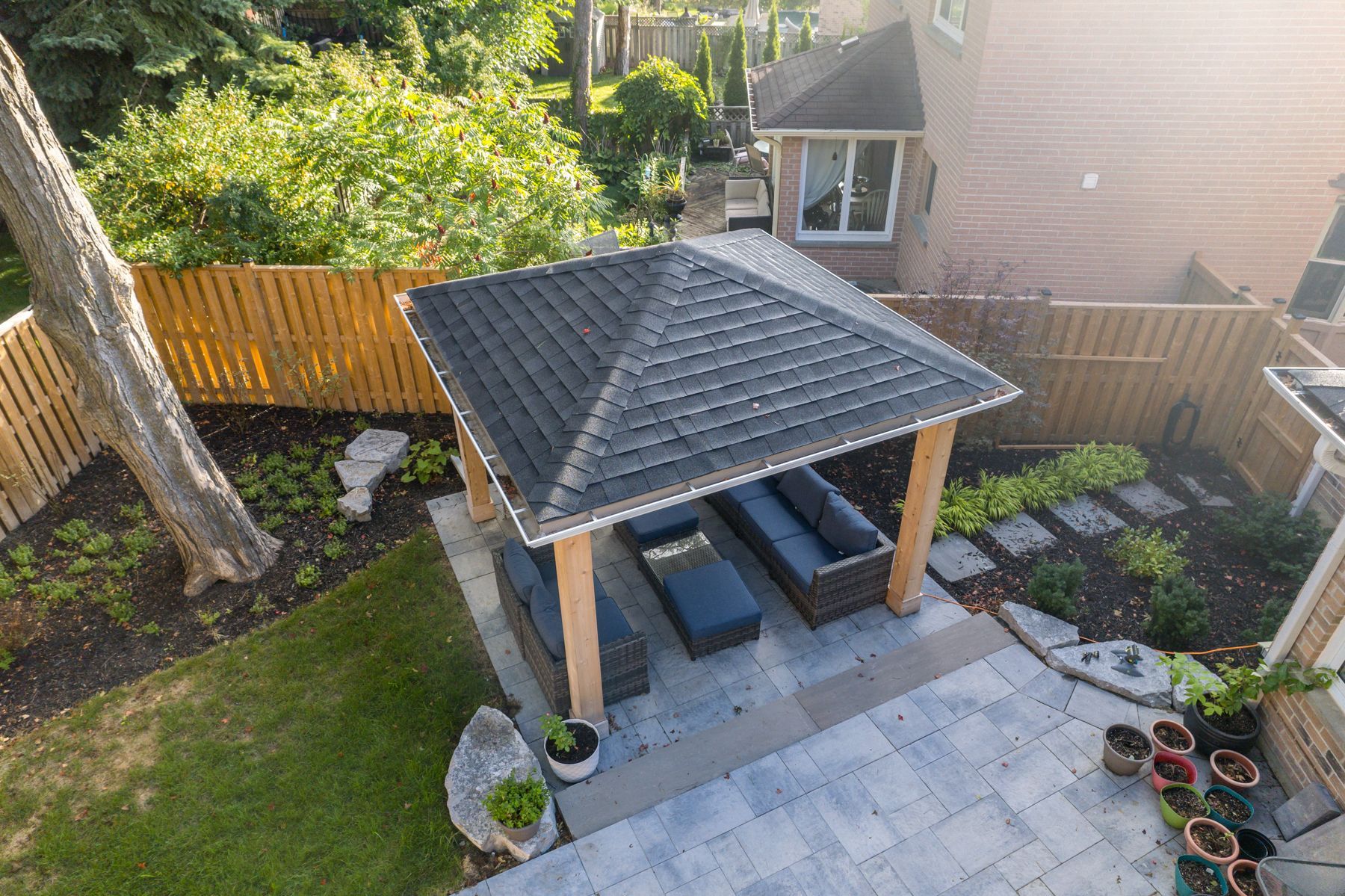 An aerial view of a gazebo in the backyard of a house.