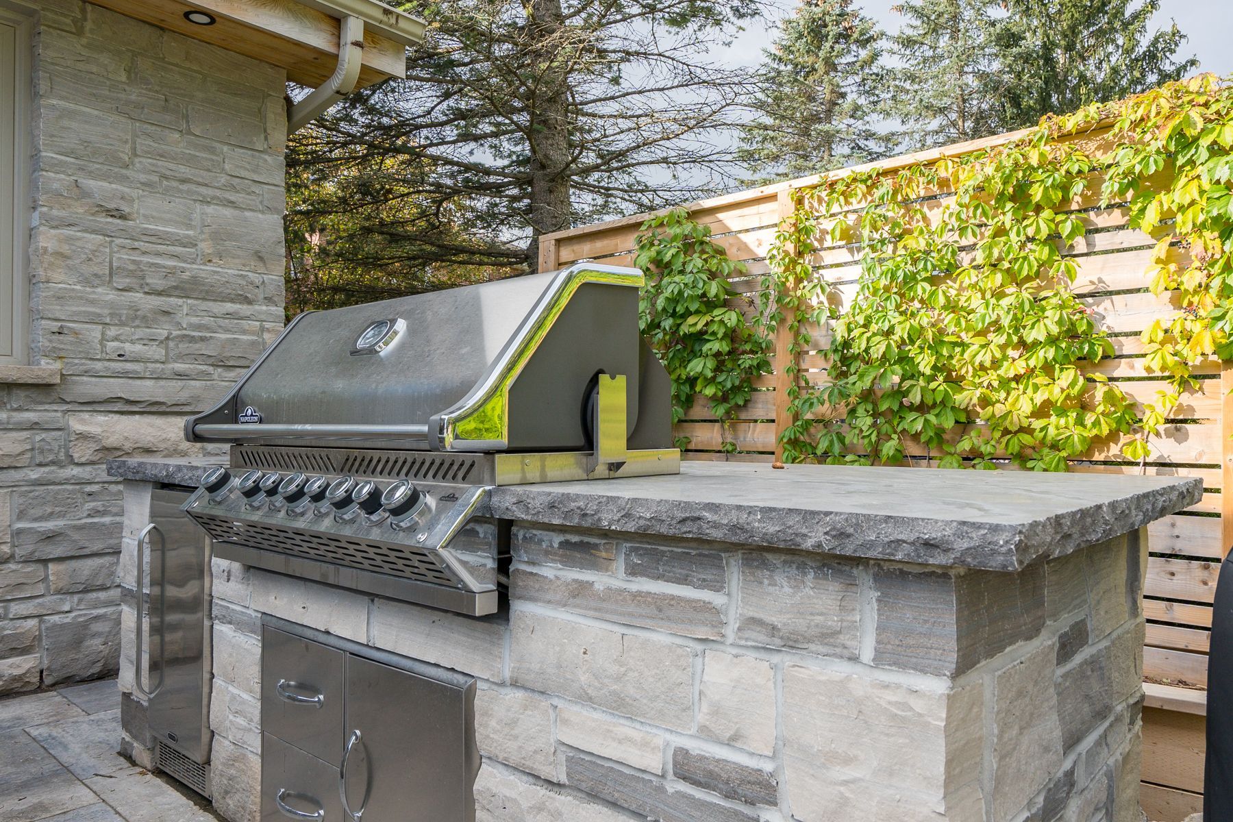 A stainless steel grill is sitting on top of a stone counter.