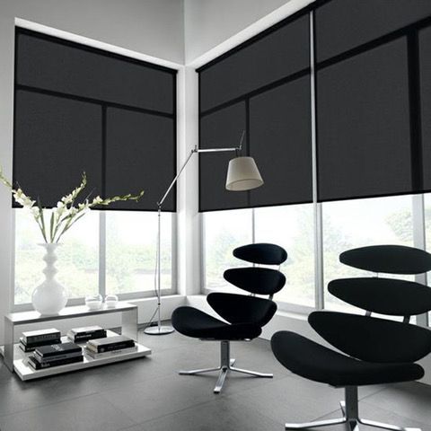 A living room with black chairs and black blinds