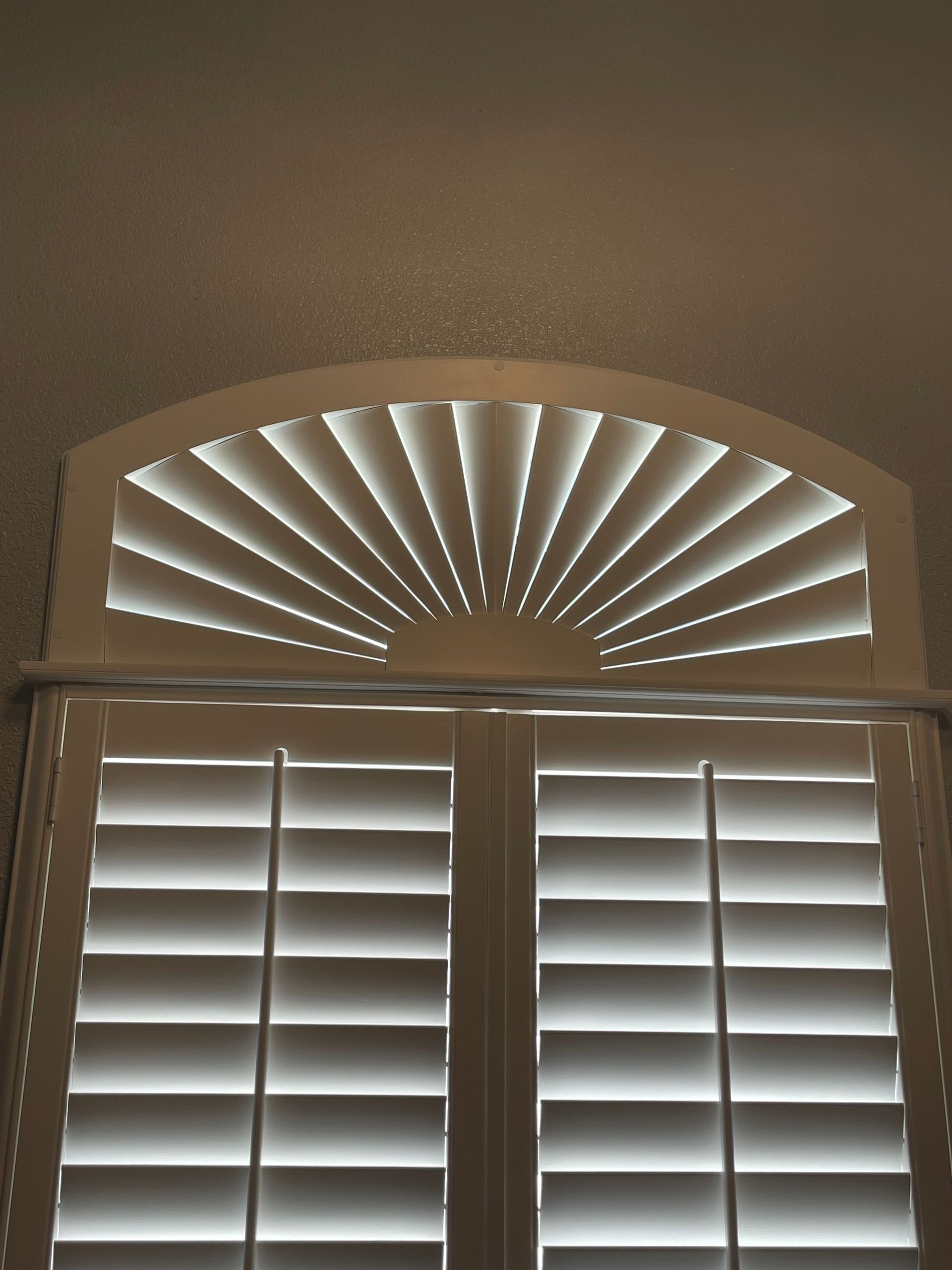 A window with arched shutters that look like a fan