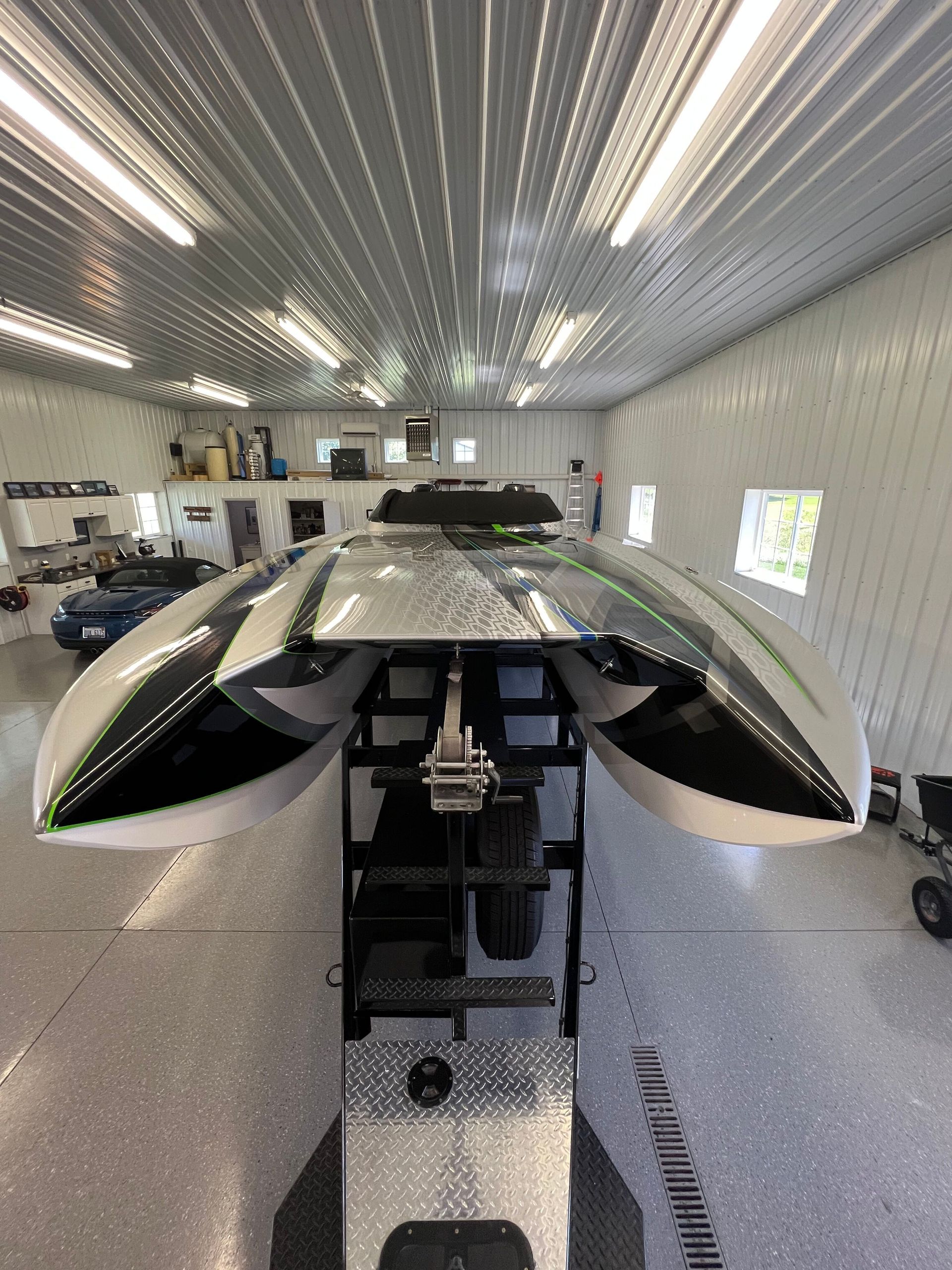 A boat is sitting in a garage with the roof open.