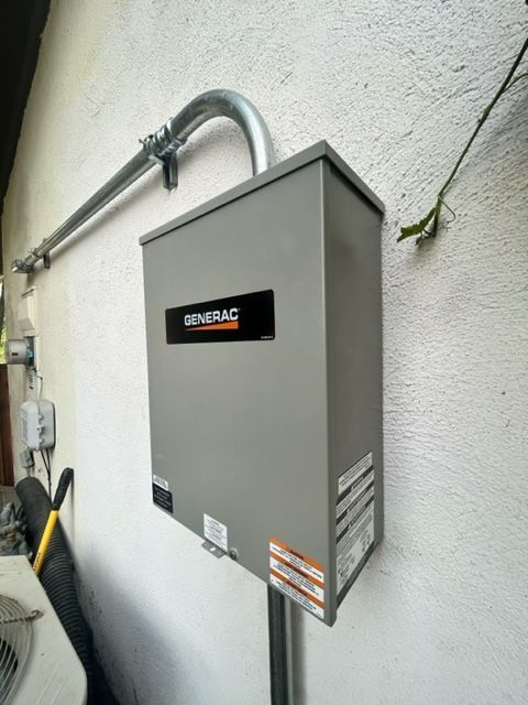 Gray Generac electrical control box mounted on an exterior wall with conduit pipes
