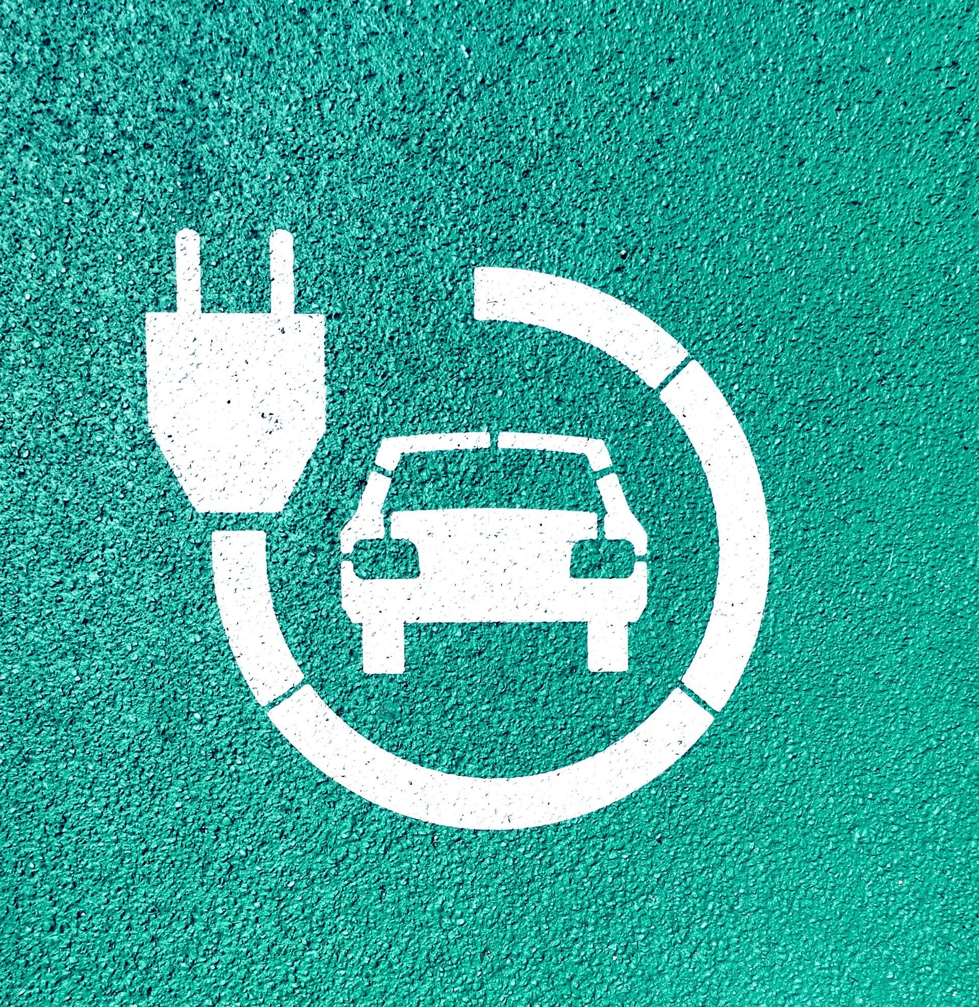 Electric car charging symbol in white on a teal background.