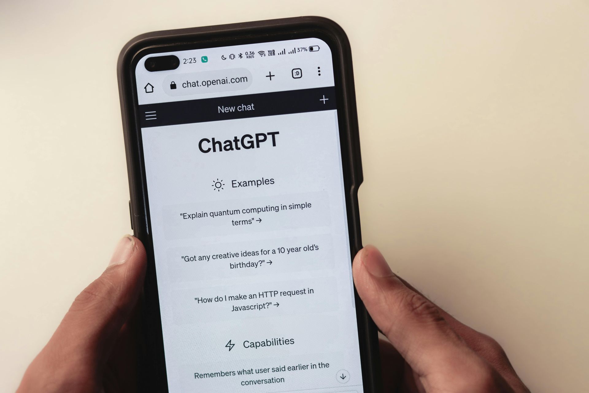 Une personne tient un téléphone portable sur lequel est écrit chatgpt sur l'écran