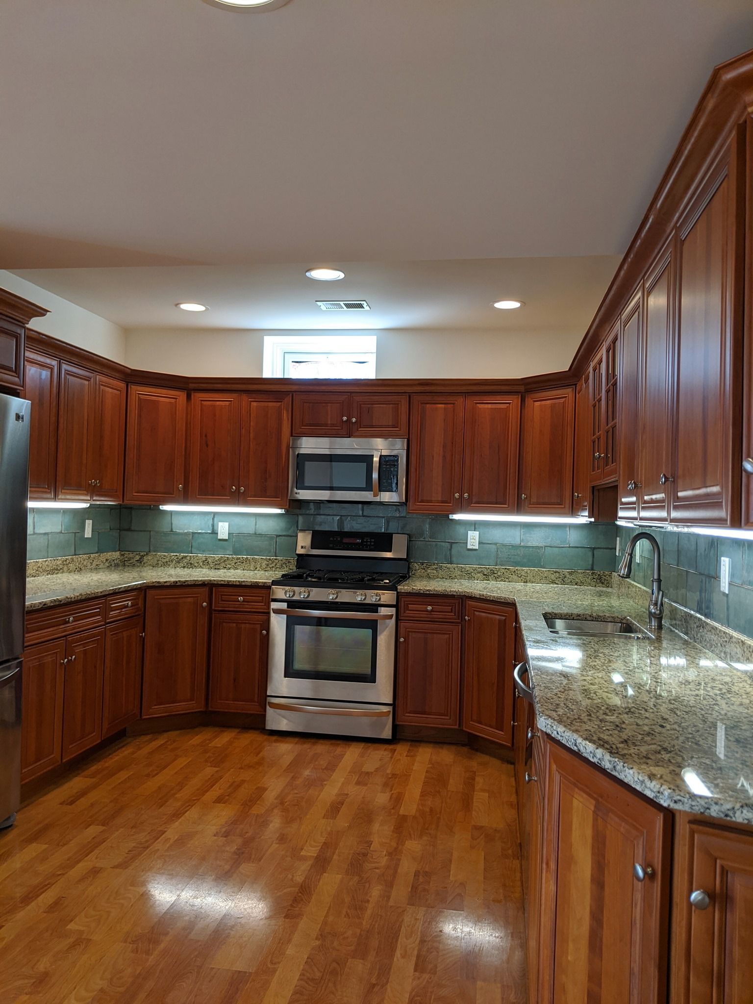 A kitchen with wooden cabinets and granite counter tops