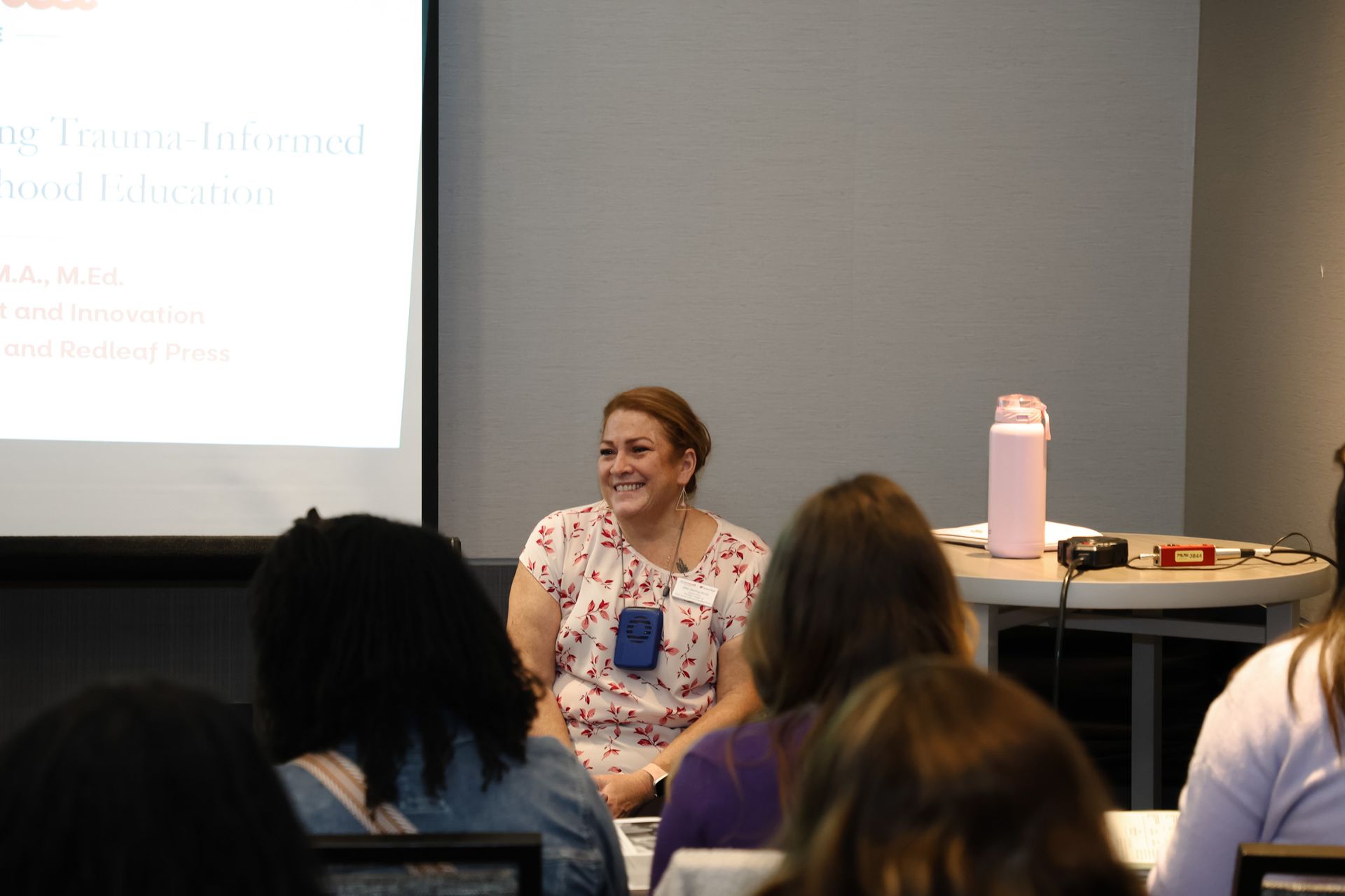 A woman is giving a presentation to a group of people