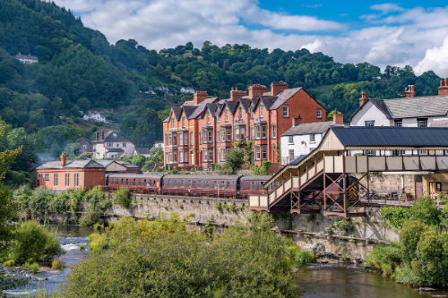 Llangollen train is pulling into a train station next to a river. Llangollen Locksmiths