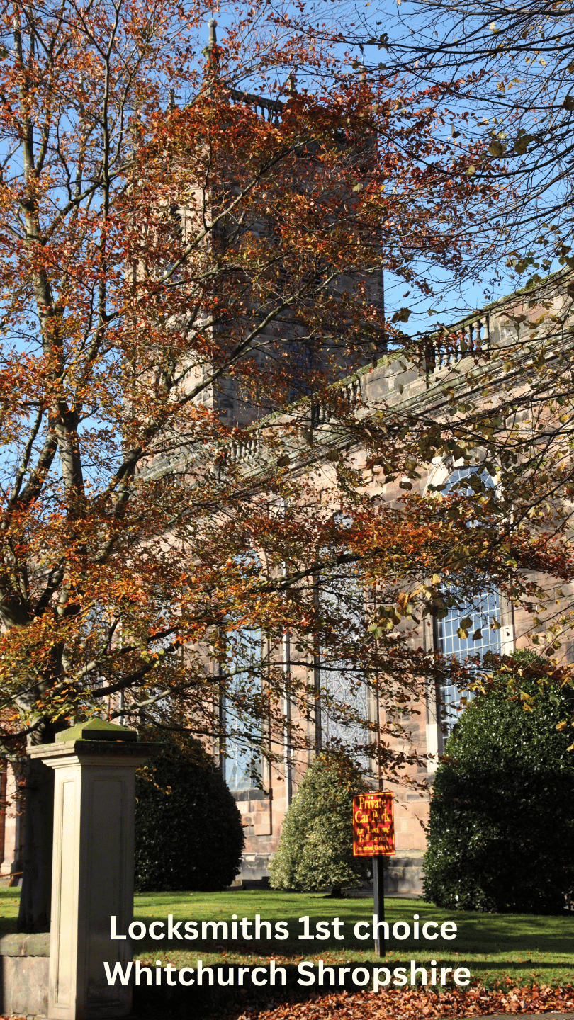 A large church with a clock tower in Whitchurch Shropshire surrounded by trees.