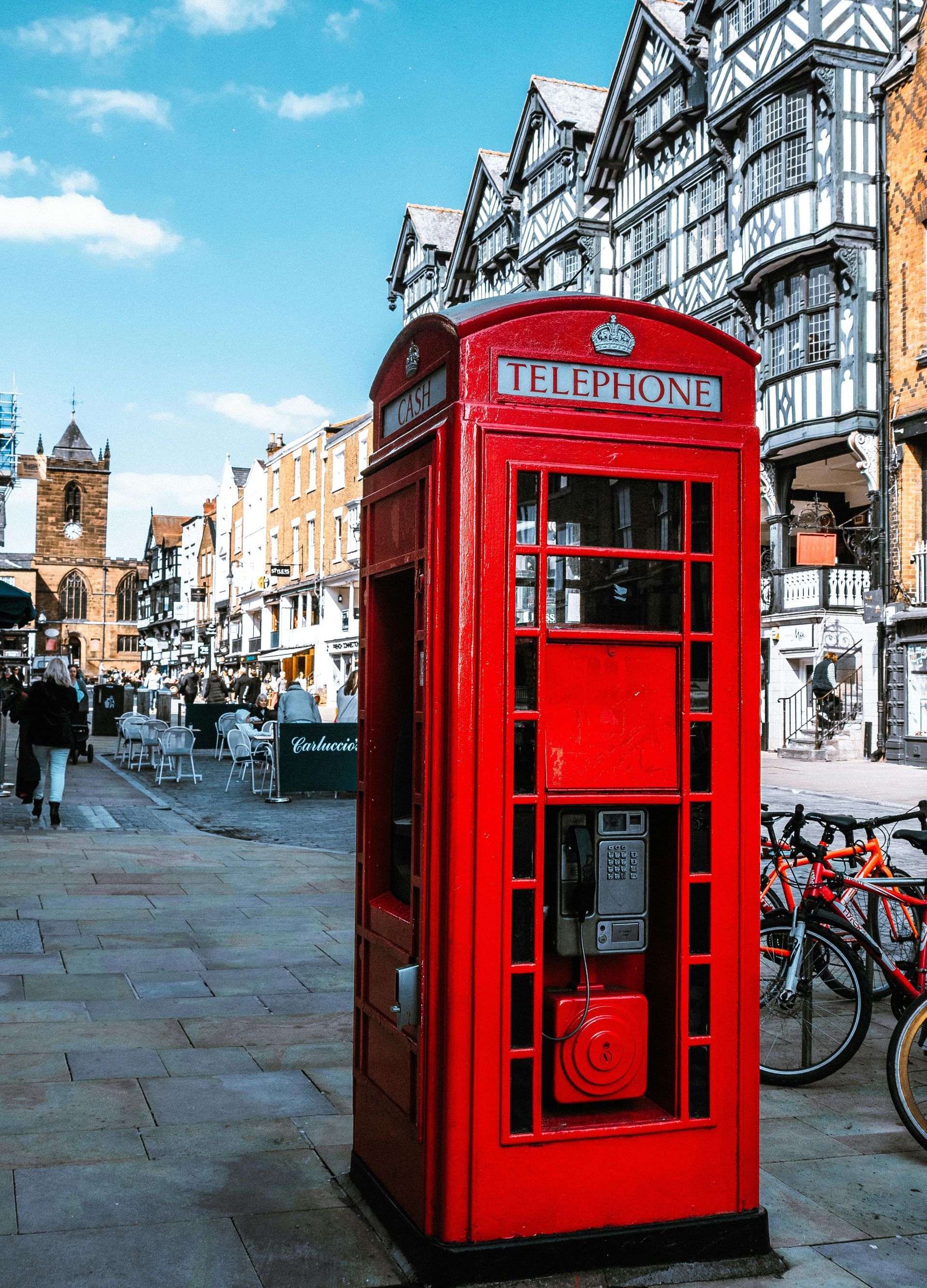 Chester red telephone booth is sitting on the sidewalk in a city. 1st choice Locksmiths Chester