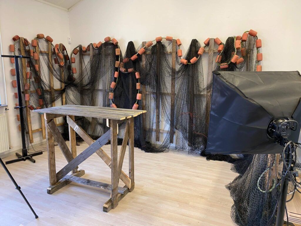 A room filled with fishing nets and a wooden table