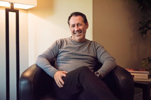 man sitting in a chair with smile on his face- hypnosis/mindfulness