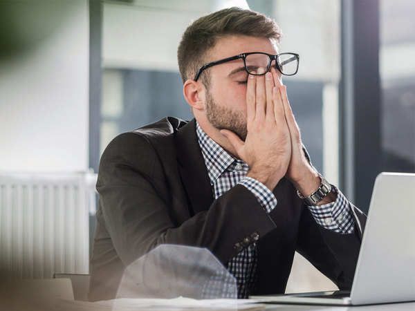 man with hands over face - stress