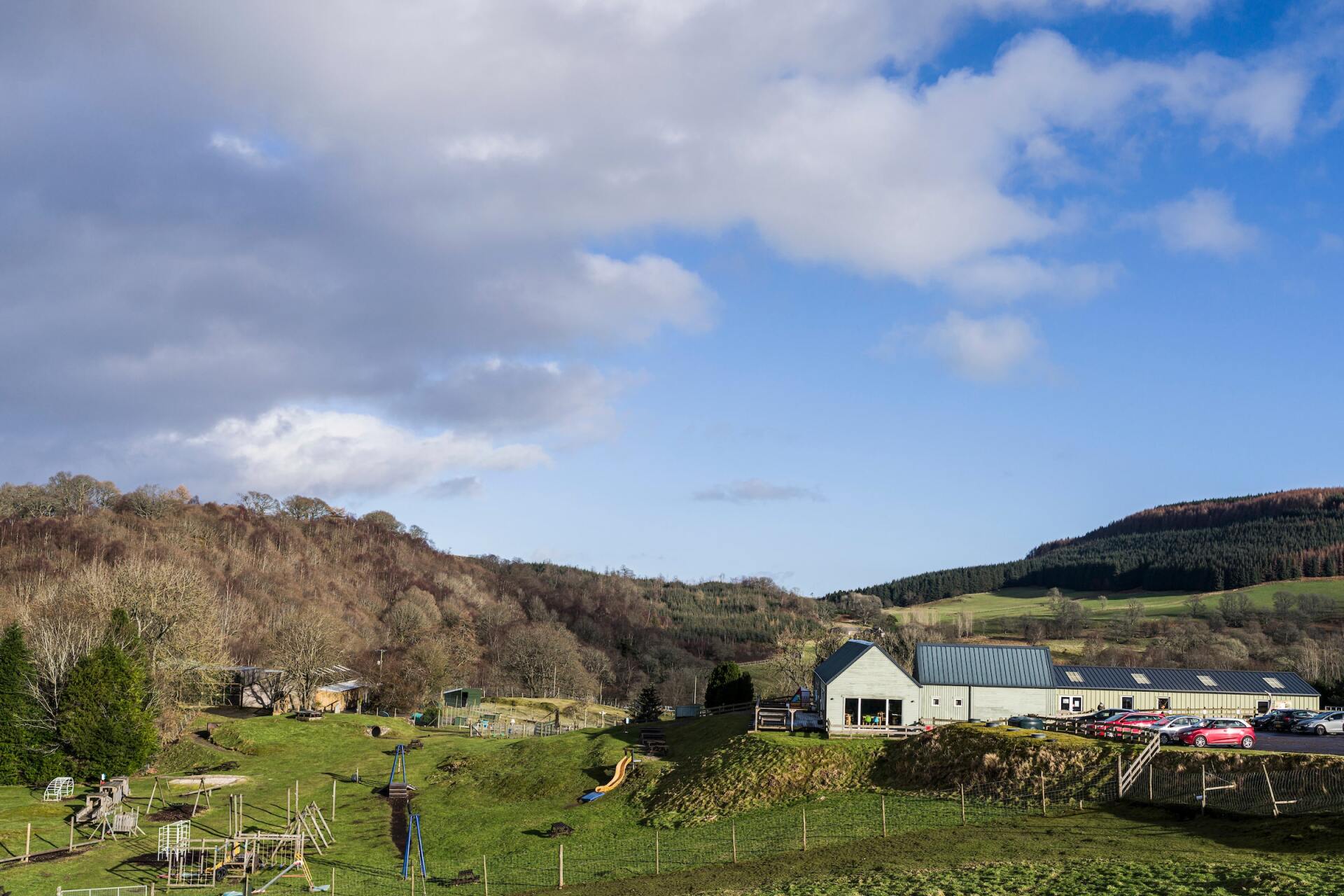 There is a house in the middle of a field with a blue sky in the background.