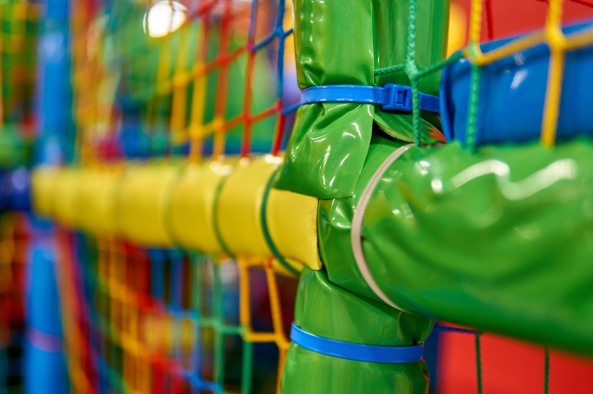 A close up of a colorful playground with a green and yellow net.