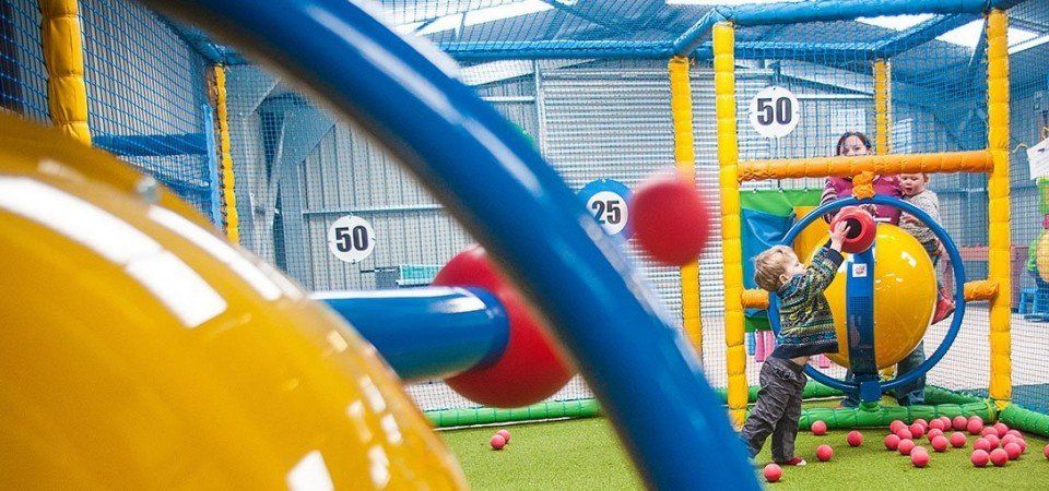 A child is playing with balls in a playground.