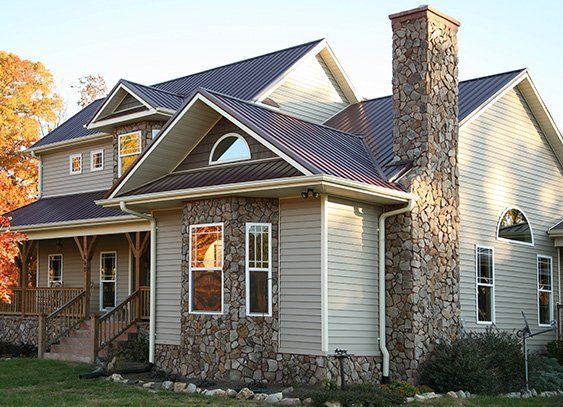 a large house with a stone chimney on the side of it