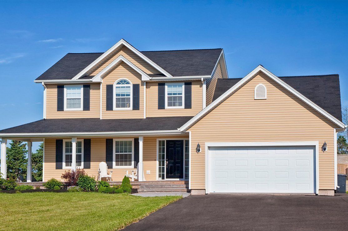 a large house with a white garage door and black shutters