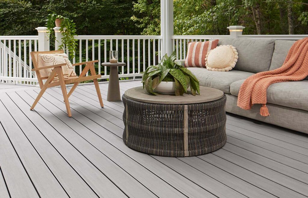 A deck with a couch , chairs , and a coffee table.