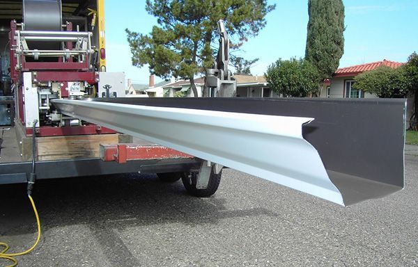 Long white metal beam being loaded onto a truck outdoors
