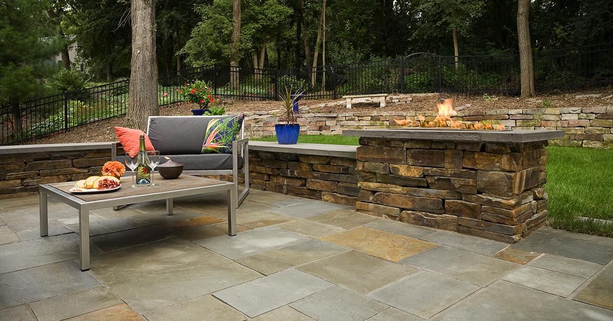 Outdoor patio with a lounge chair, fire pit, and stone built-in seating