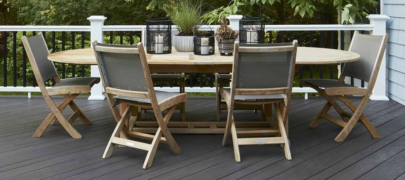 Wooden patio dining set with cushioned chairs around a table on a deck