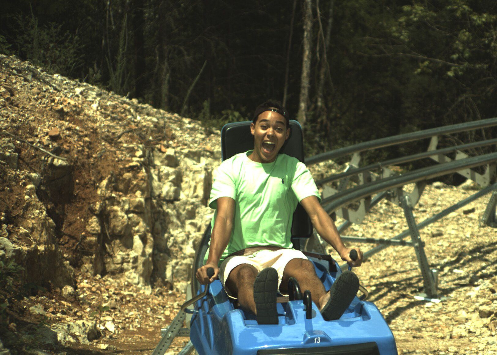 A boy in green shirt enjoying riding in coaster