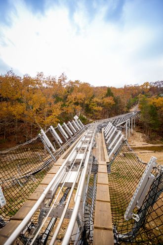 Mountain coaster track descending into vibrant fall foliage in Branson