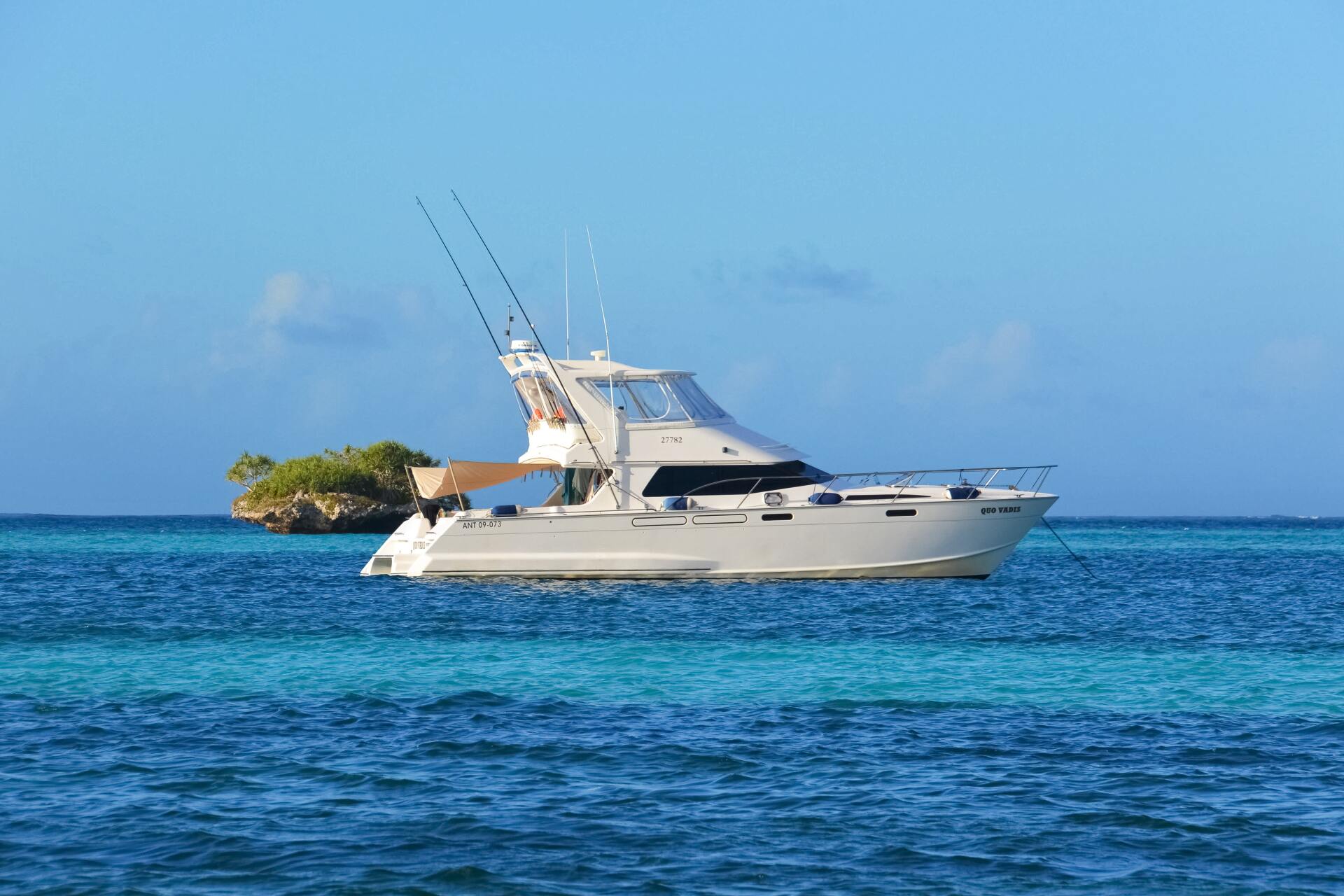 Fishing boat floating on clear turquoise water under a bright blue sky