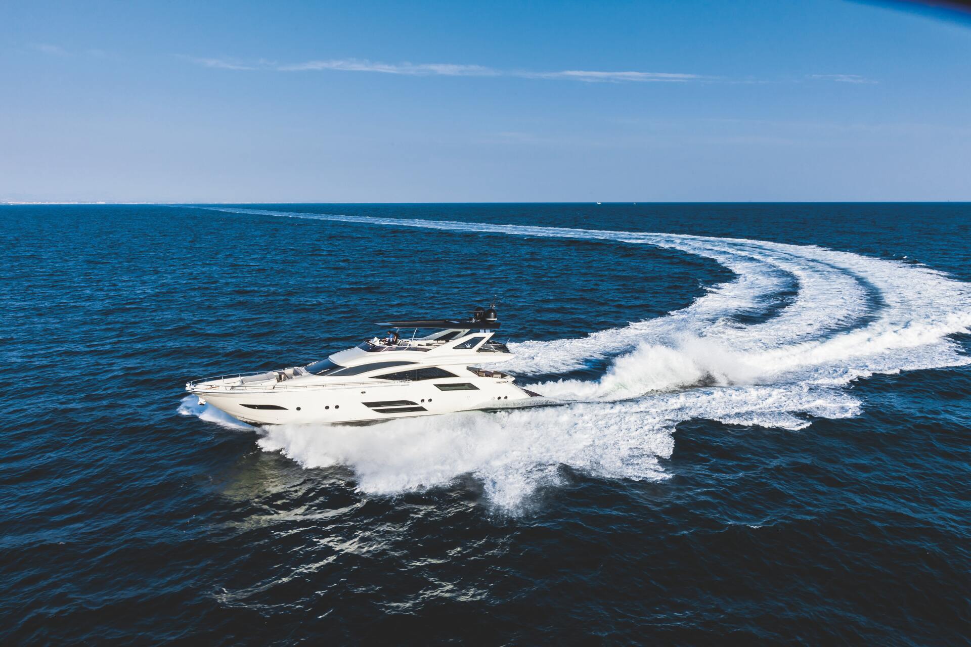 Speedboat making sharp turns and trails in open ocean water