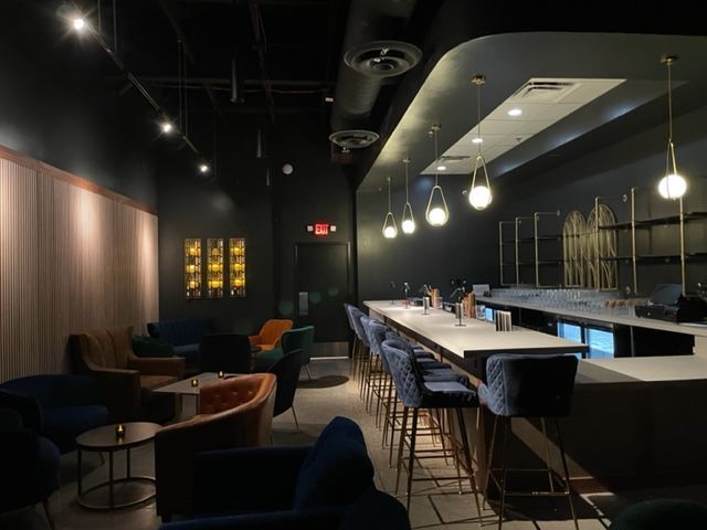 A restaurant with a long bar and tables and chairs