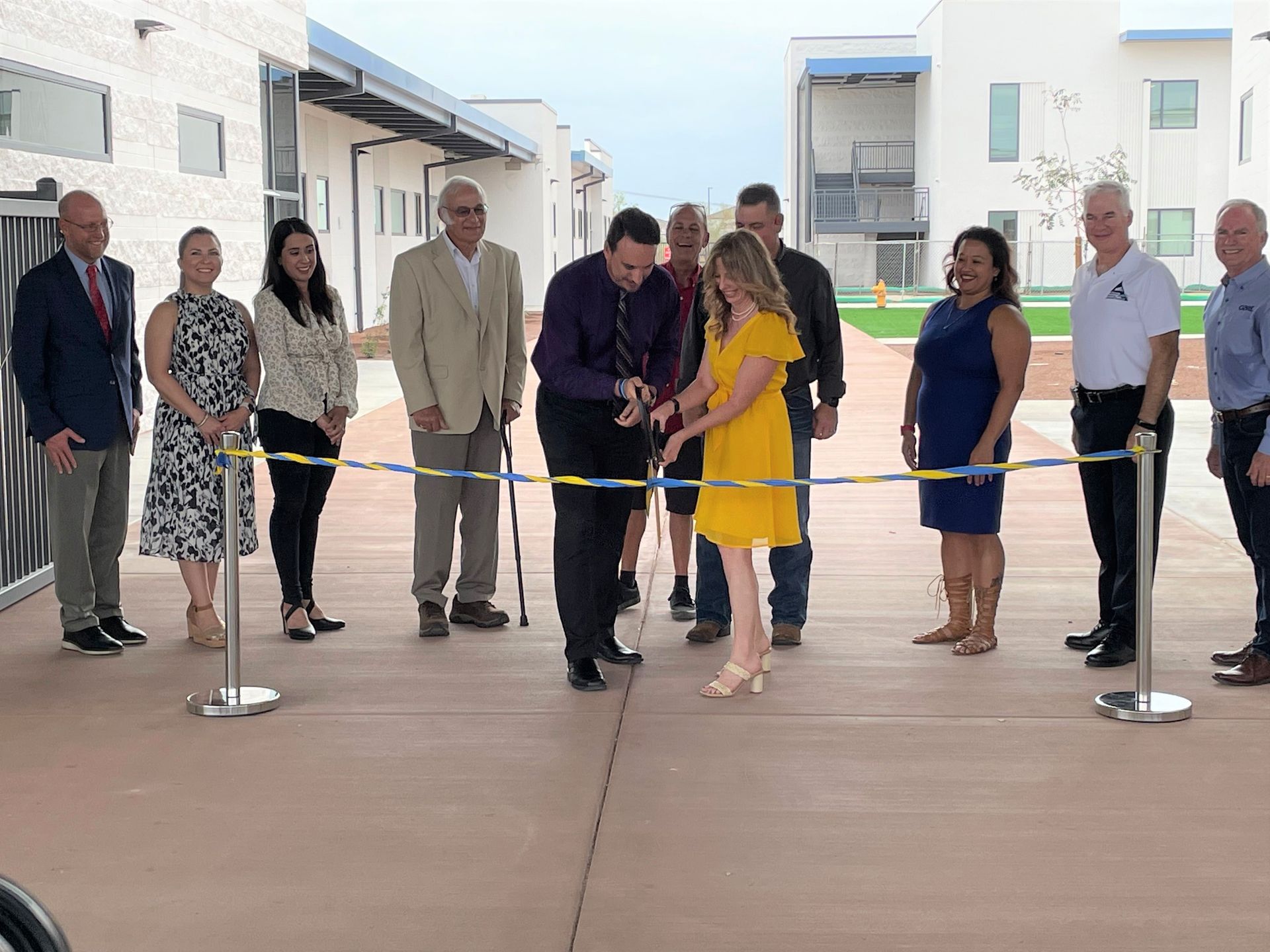 A group of people are standing around a ribbon cutting ceremony.