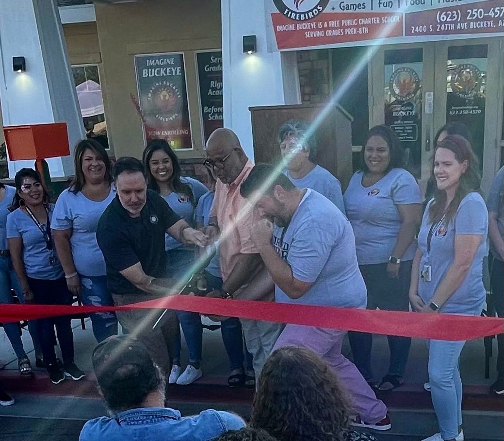 A group of people are cutting a red ribbon in front of a restaurant.