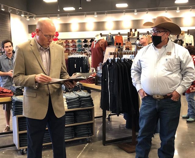 Two men in cowboy hats are standing in a clothing store