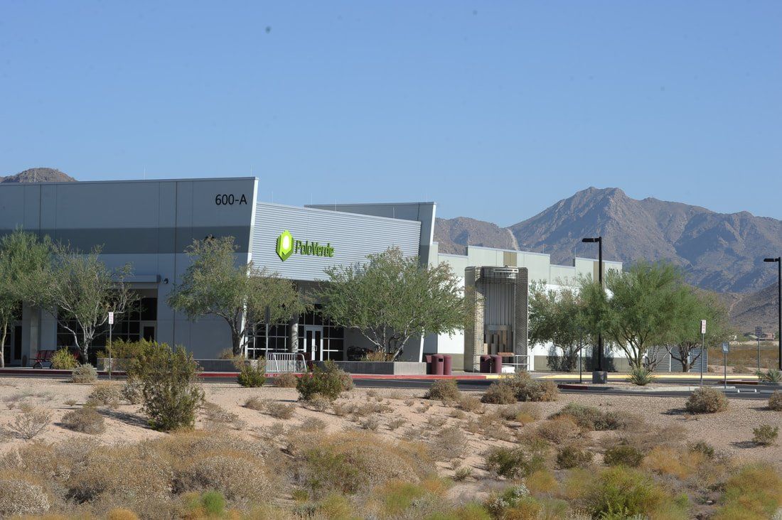 A large building in the middle of a desert with mountains in the background